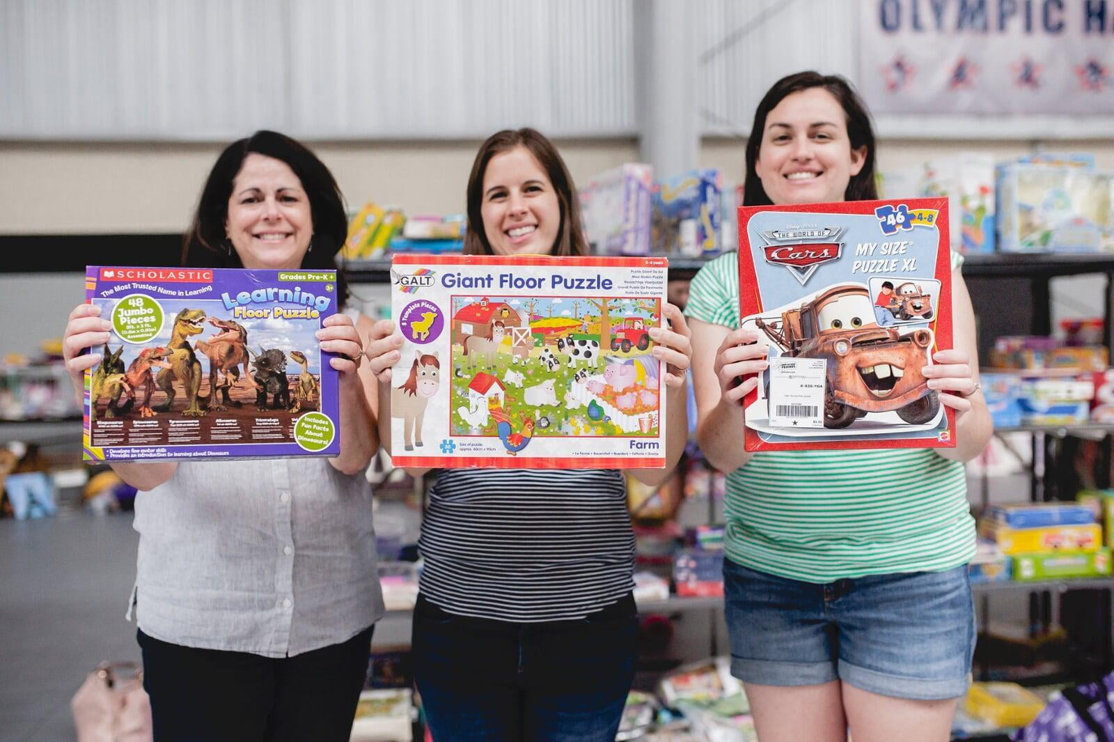 Beautiful mom holds two boys tops—one in each hand—as she shops the deals at her local sale.